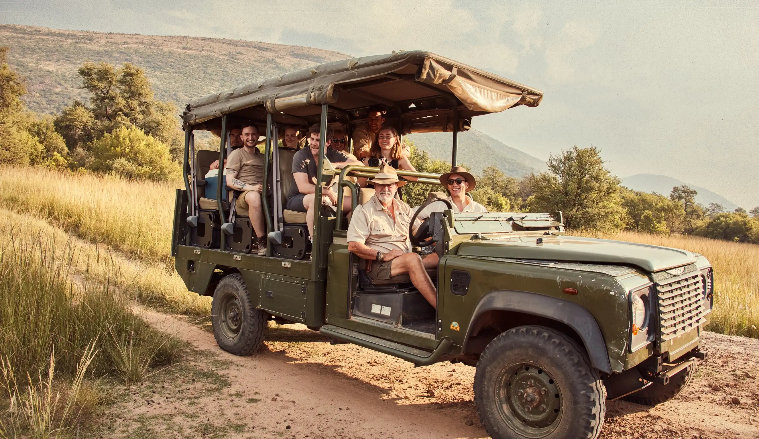Big group sitting in safari truck amid the savanna