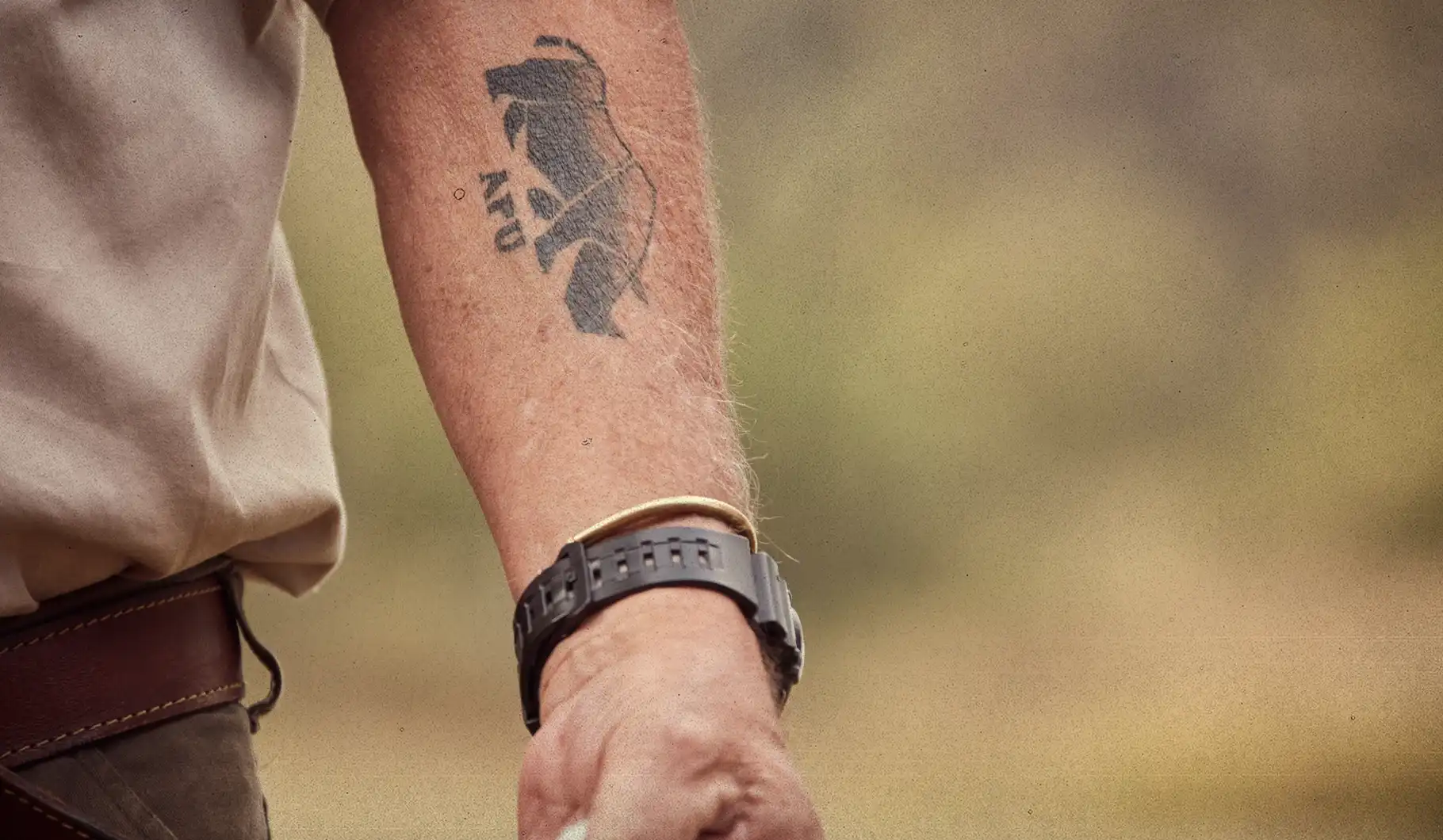 Close-up of an anti-poaching-unit tattoo in the shape of a rhinoceros, on the inside of a forearm.