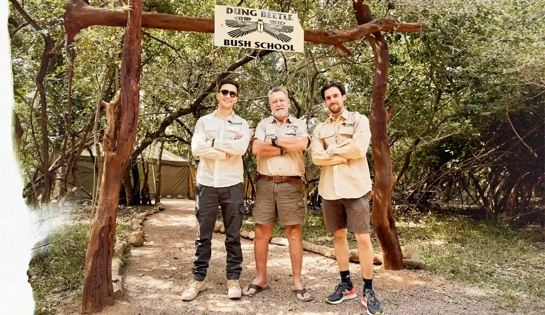 Group image of AMES founder Marlon Braumann, co-founder Christoph Rösler and SA coordinator Les Brett, standing infront of the gates to the Dung Beetle Bush School.