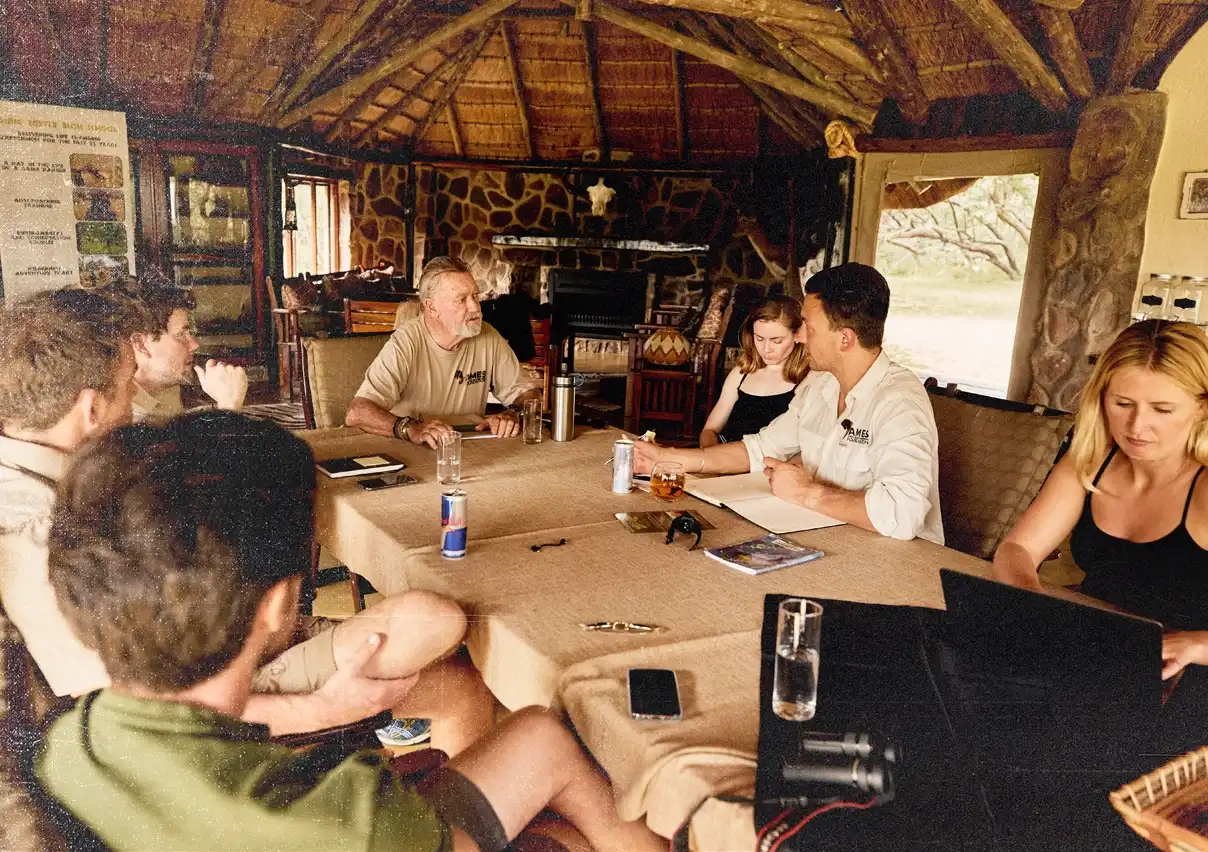 Das Team hat sich im Safari-Gemeinschaftsraum um einen Tisch versammelt und plant seine nächsten Schritte