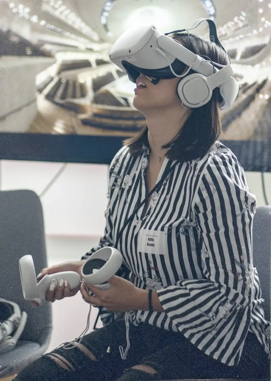 Person in gestreifter Bluse trägt ein weißes VR-Headset